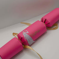 Personalised Regency style pink cracker with gold ribbon and name tag ideal for celebrations.