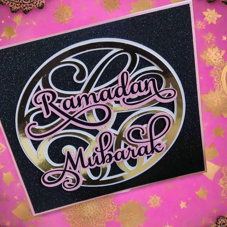 "Ramadan Mubarak" card with glittery black background and gold and pink lettering, on a festive pink and gold background.


