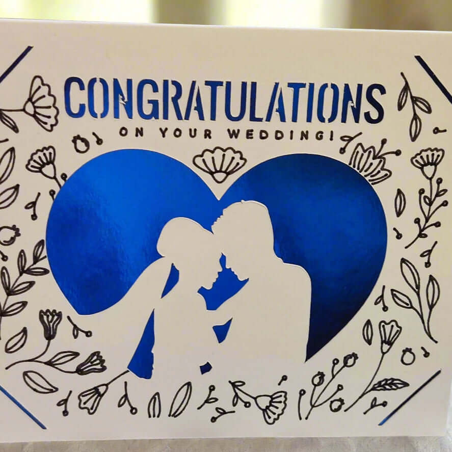 Handmade wedding congratulations card featuring blue heart, floral design, and couple silhouette.