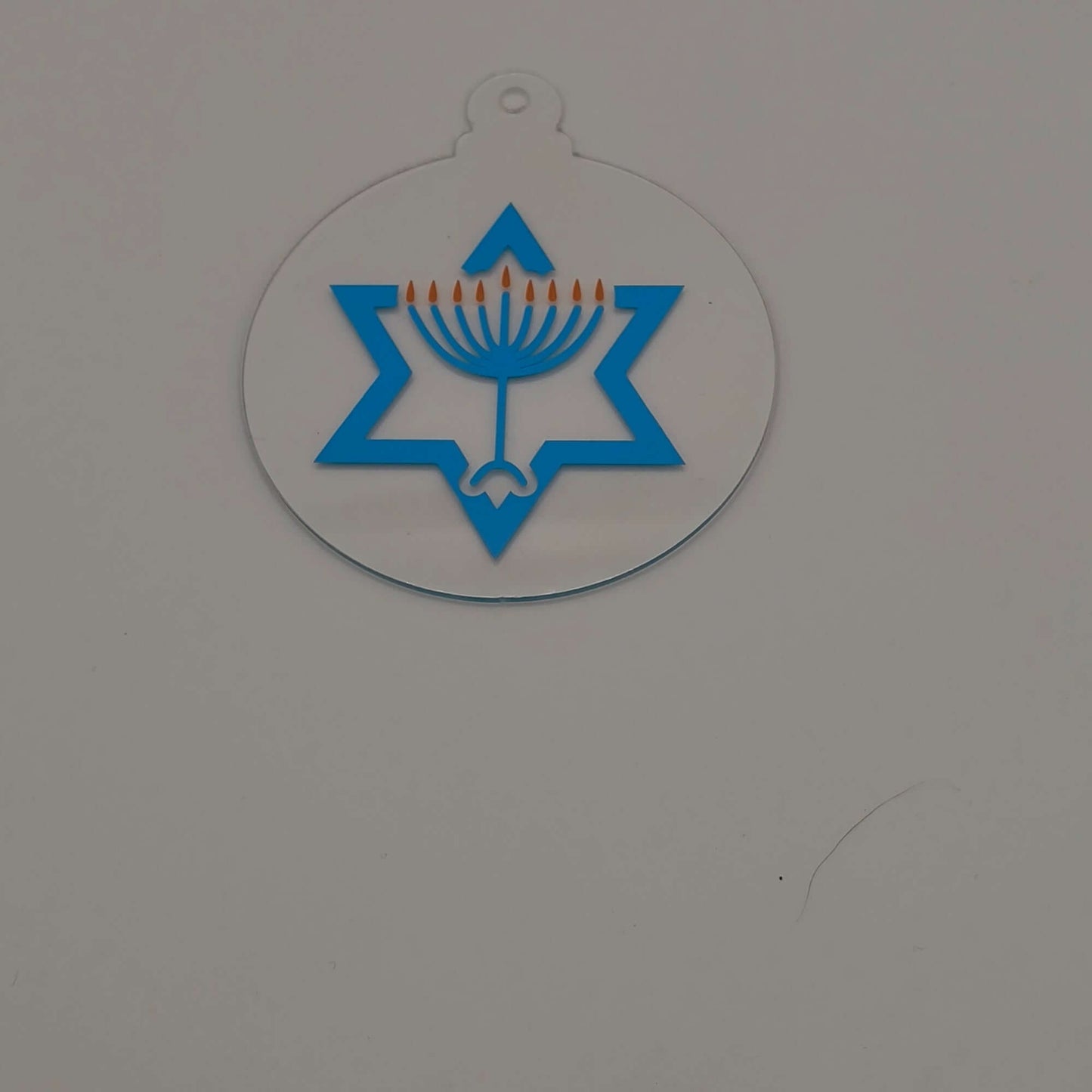 Acrylic Hanukkah decoration with menorah and Star of David design on white background.