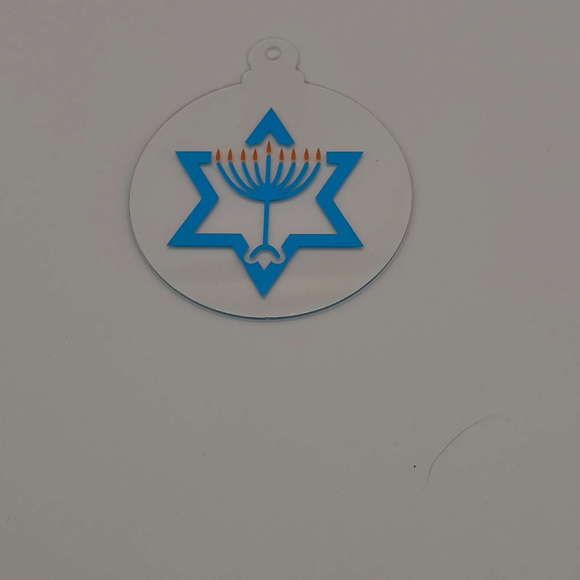 Acrylic Hanukkah decoration with menorah and Star of David design on white background.