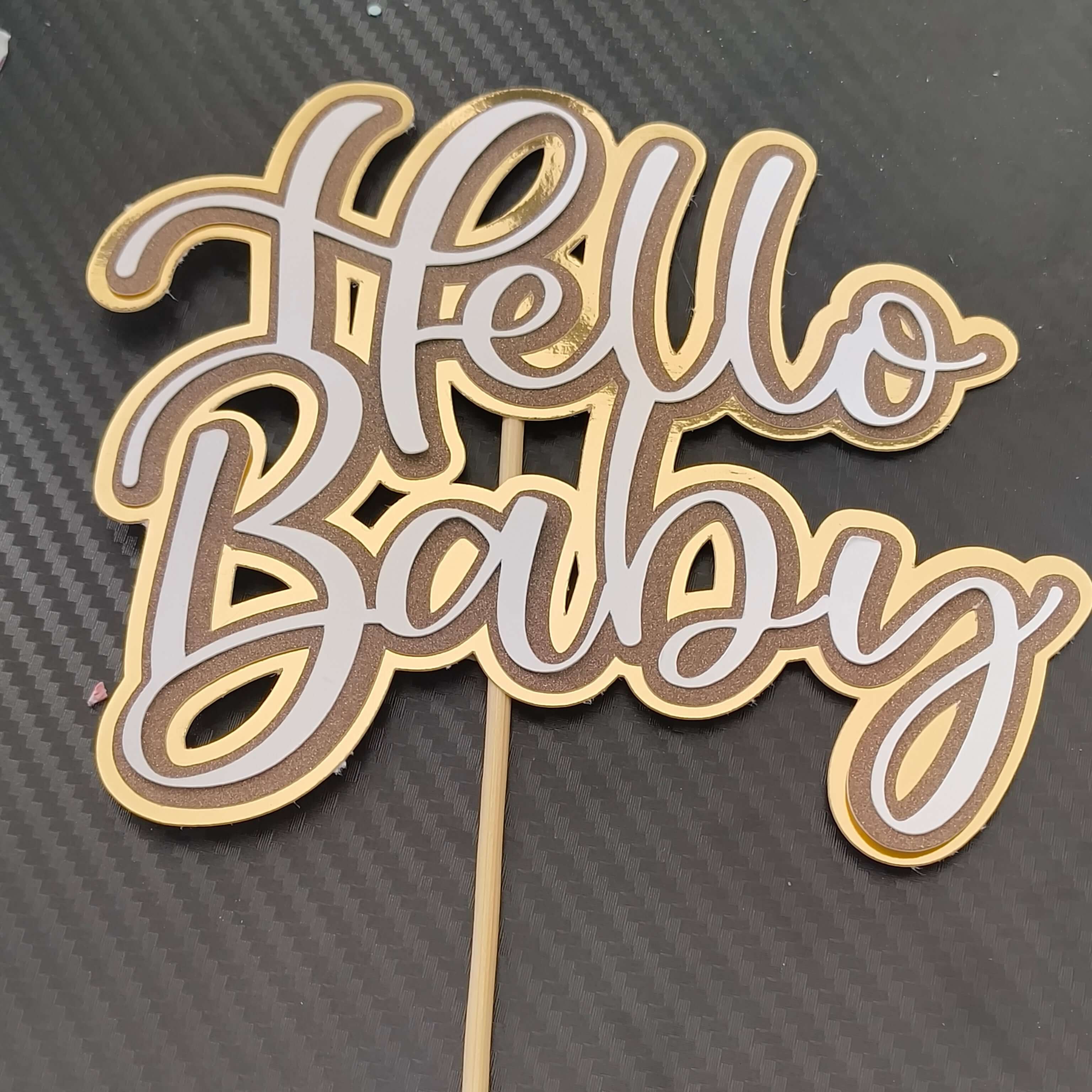 Hello Baby cake topper in gold layered cardstock design for baby shower celebrations.