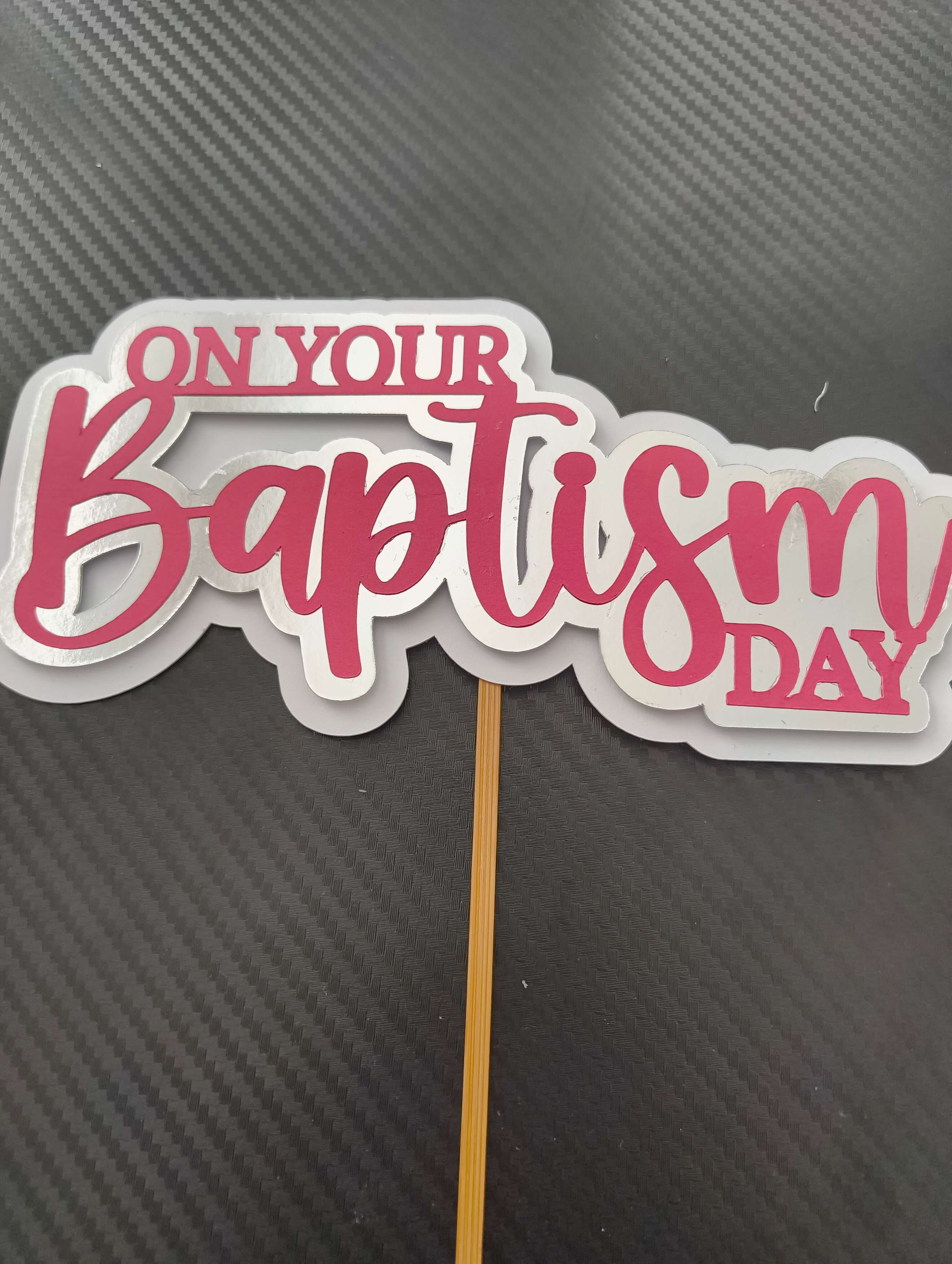 Personalised baptism cake topper with pink script saying 'On Your Baptism Day' for Christening decorations.