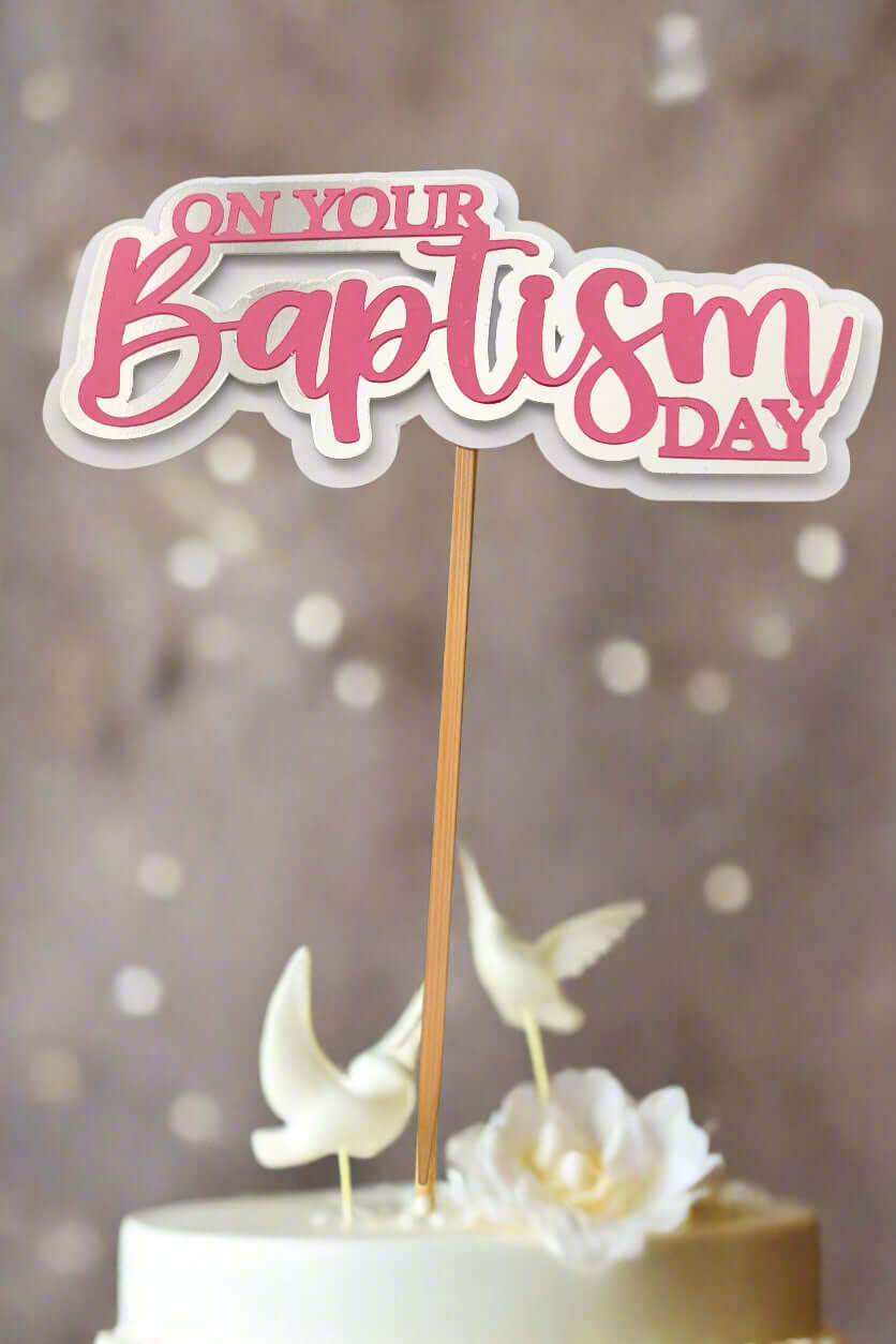 Personalised Baptism cake topper featuring the phrase 'On Your Baptism Day' in pink and white.