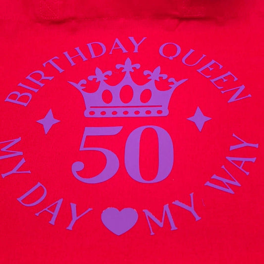 Close-up of red tote bag showing purple crown and number 50 with birthday queen slogan.