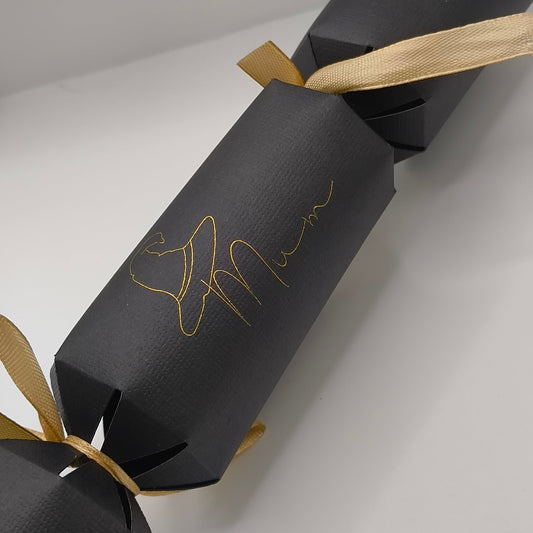 Black Christmas cracker with gold ribbon and witch hat “Mum” motif on textured card