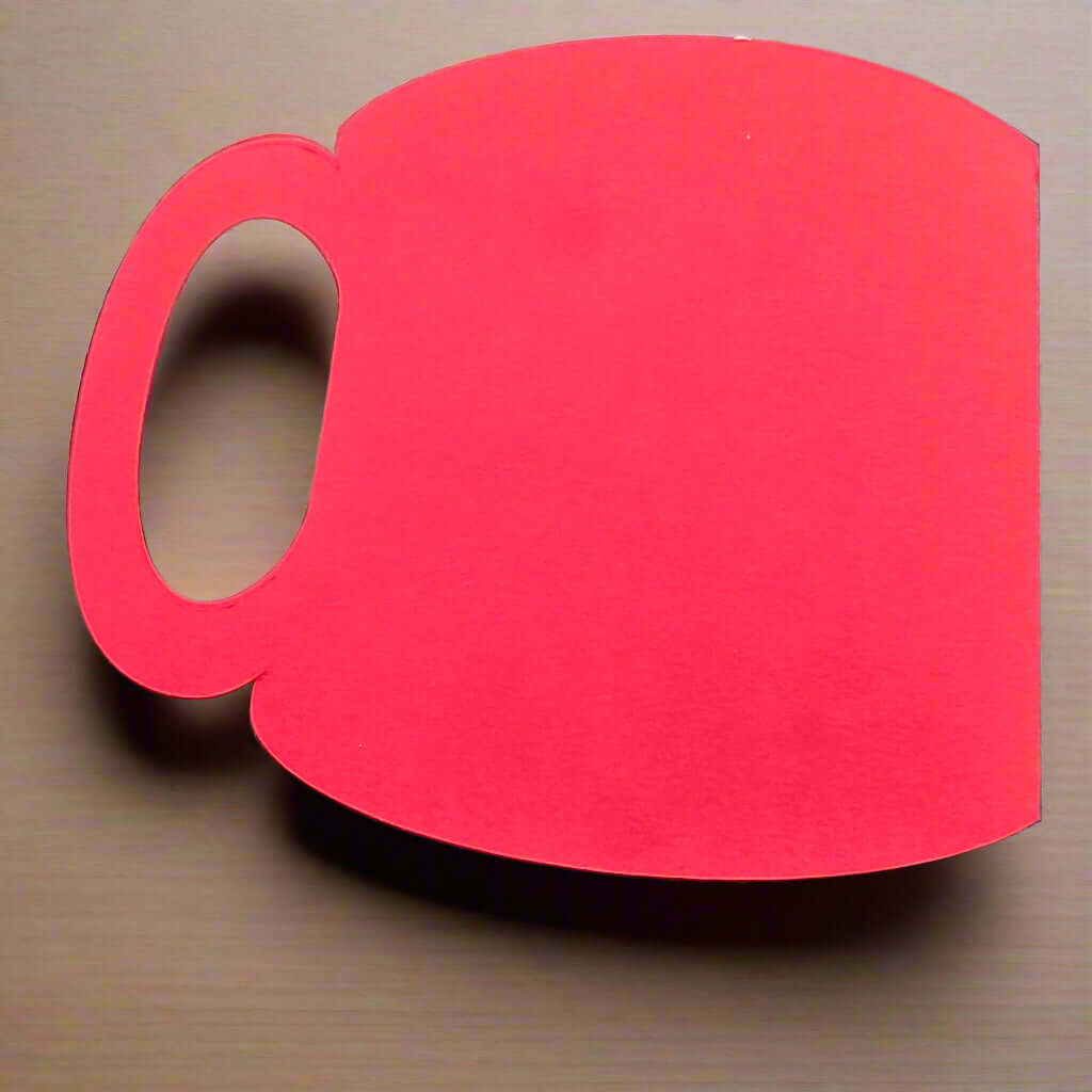 Blank red mug-shaped cardstock cutout placed on a light wooden surface – ideal for Christmas crafting, handmade gift card holders, or festive DIY projects.