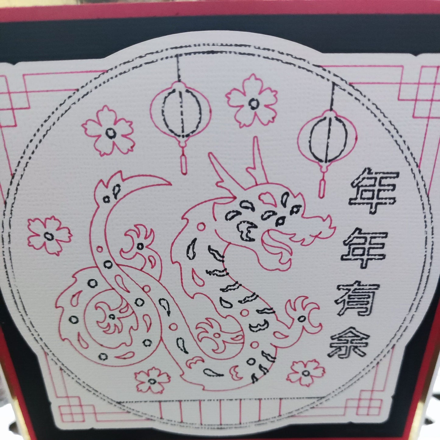 Illustration of a dragon design on a Chinese New Year card with lanterns and floral motifs.