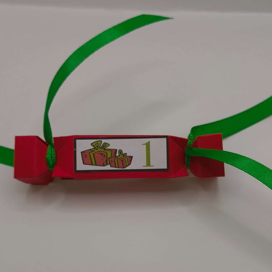 Red handmade Christmas cracker with green ribbon and number 1 gift design label