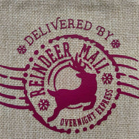 Close-up of reindeer and "Delivered by Reindeer Mail Overnight Express" text in burgundy print on natural hessian bag.