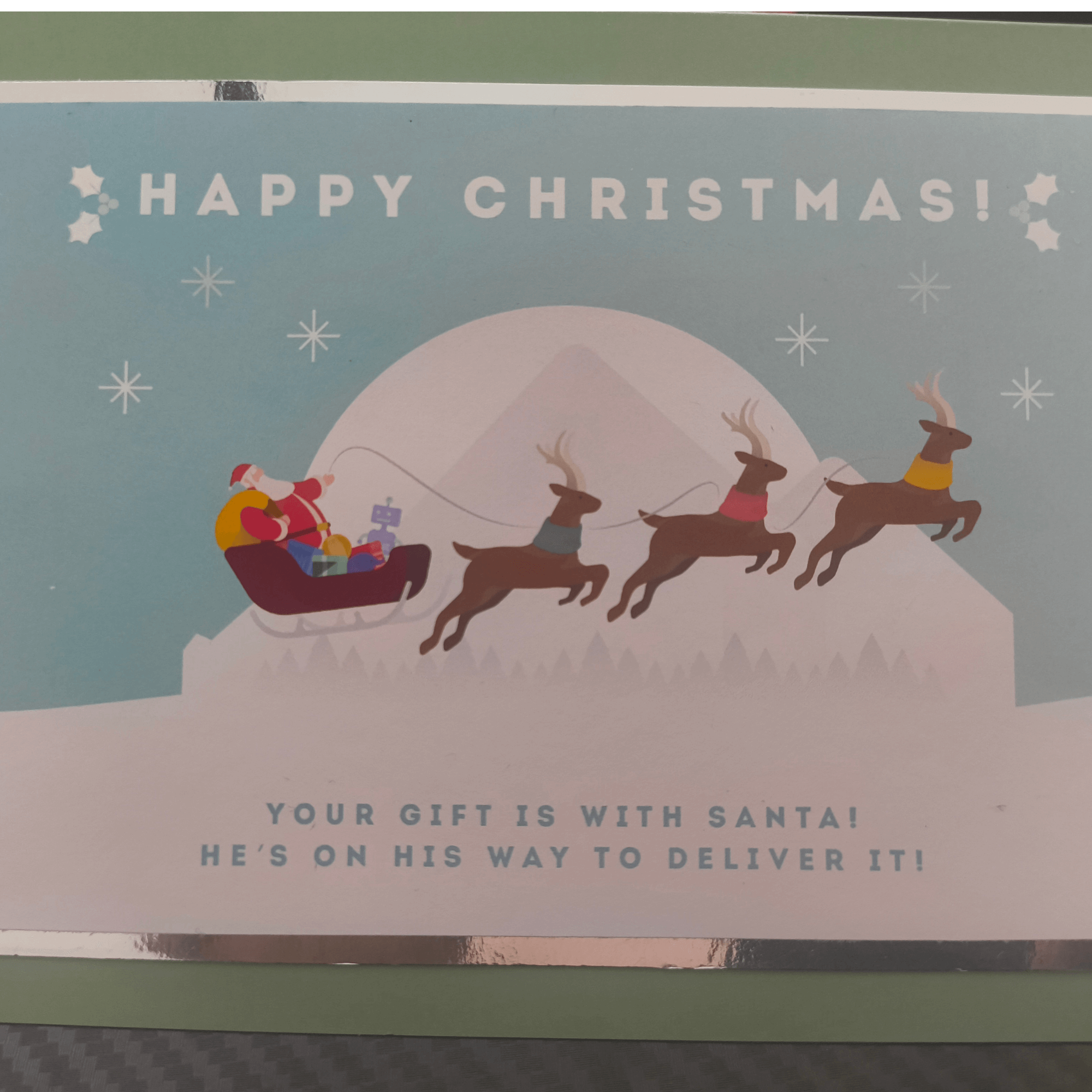 Colorful Christmas card featuring Santa with reindeer, delivering gifts, and a festive message.