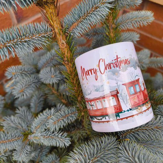 Close up of Christmas train mug with snowy winter illustration on pine tree