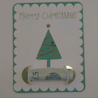 Vertical view of Christmas tree money holder card with rolled £5 note inside gold and white holder.