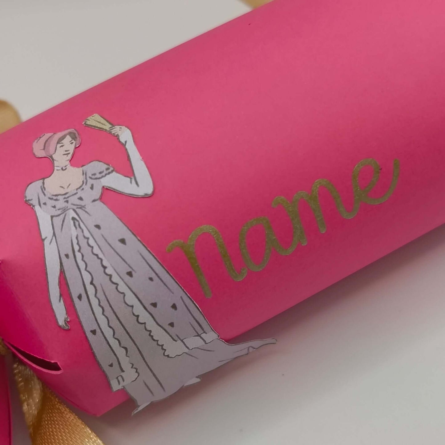 Personalised Regency style cracker in pink with a vintage illustration and gold ribbon, perfect for themed parties.