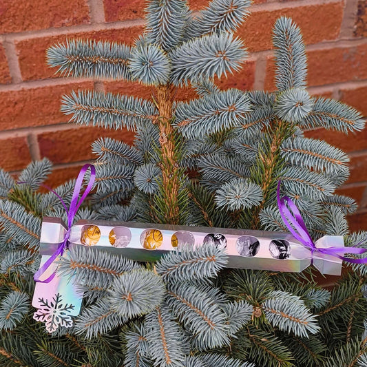 Personalised chocolate cracker gift displayed on a Christmas tree branch with festive ribbons.