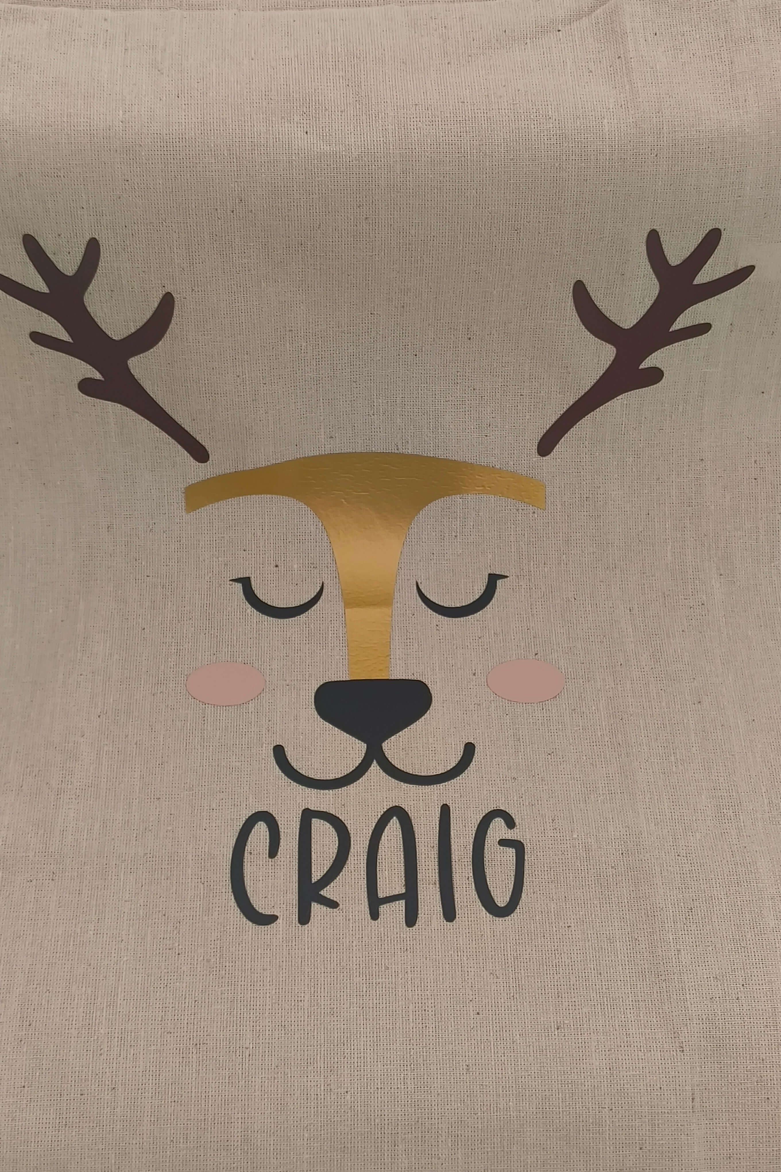 Personalised reindeer gift sack featuring a cute reindeer face and the name 'Craig' in bold black letters.