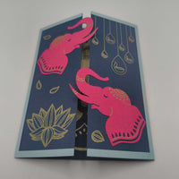 Handmade Diwali card featuring pink elephants and gold lotus on navy background for festive celebrations.