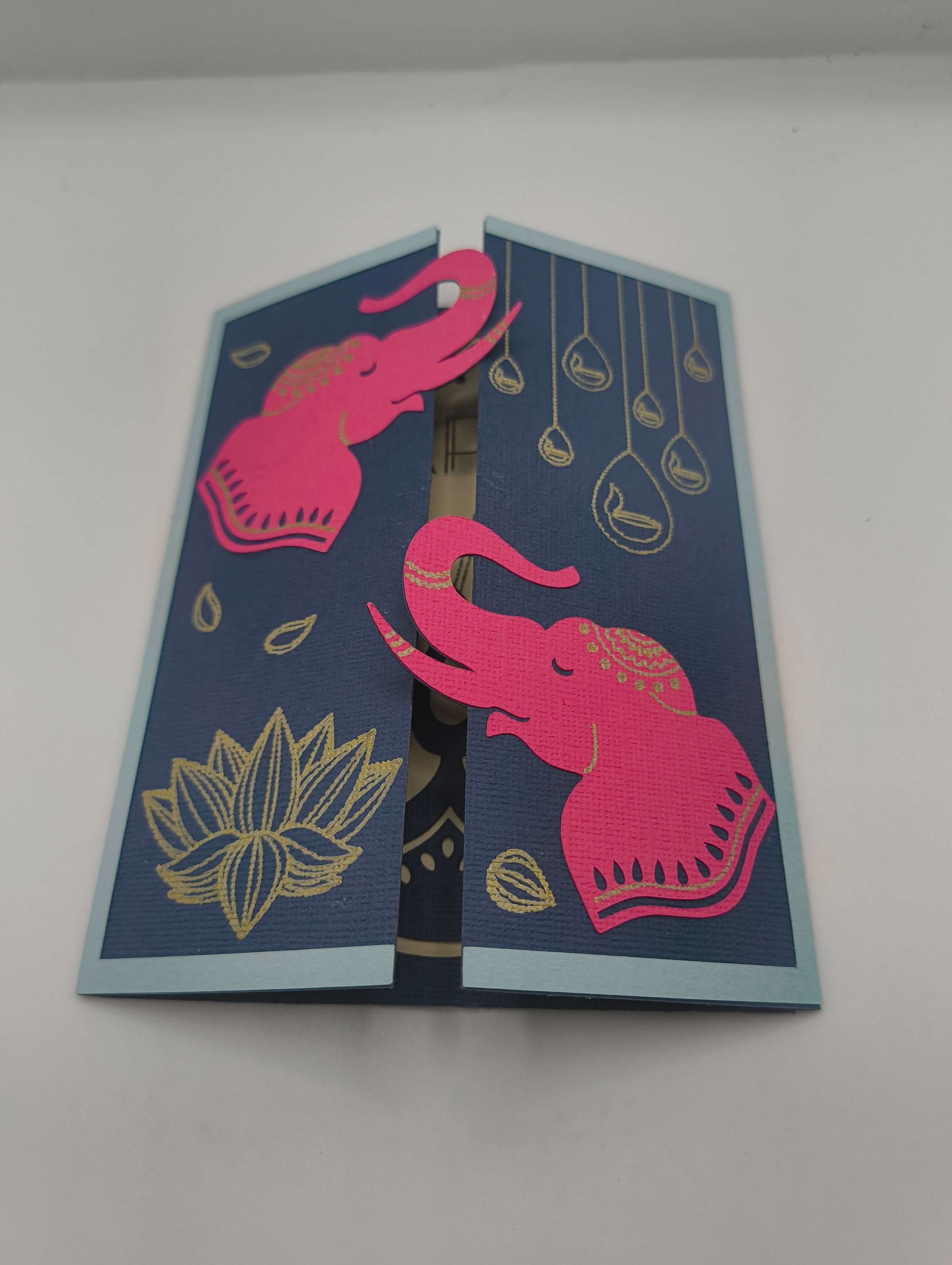 Handmade Diwali card featuring pink elephants and gold lotus on navy background for festive celebrations.