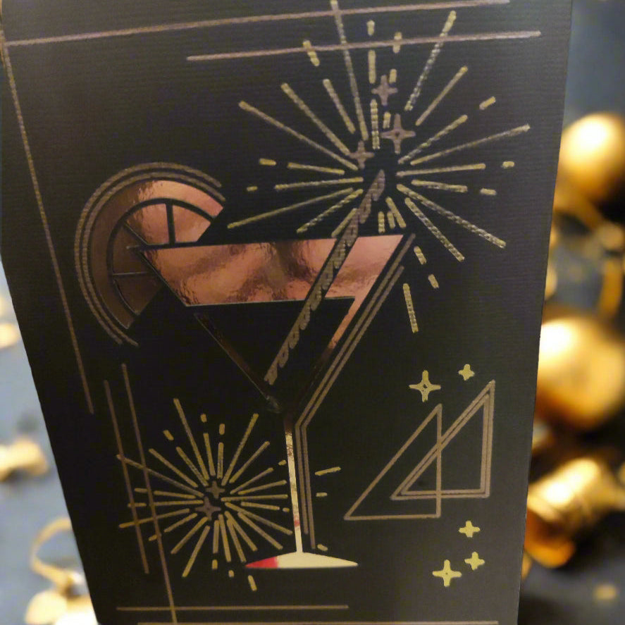 Elegant black card with gold foil cocktail glass, lemon slice, and festive fireworks design, ideal for parties and celebrations.
