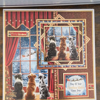 Close-up of handmade Christmas card with three dogs sitting by a snowy window, greeting reads “May All Your Christmas Wishes Come True.”

