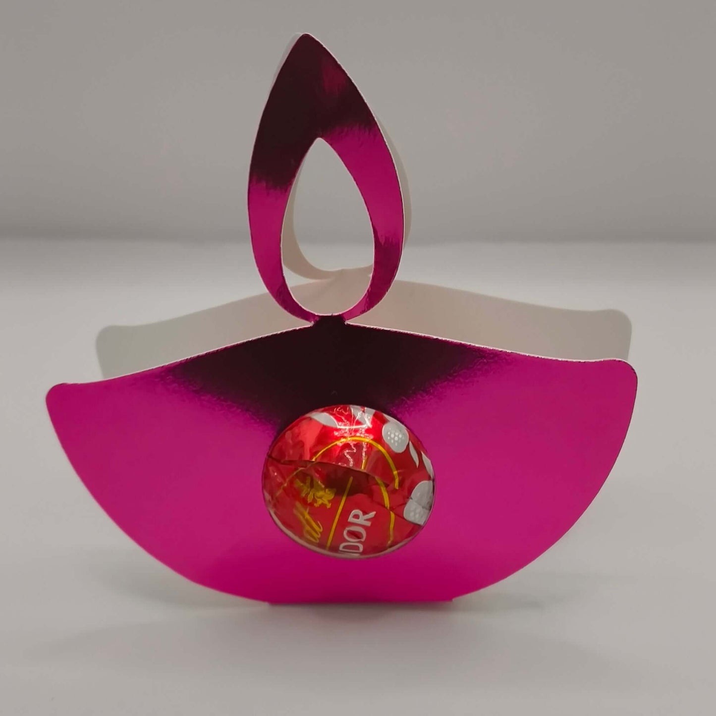 Pink metallic Diwali diya favour for sweets or gifts, featuring a shiny design with a chocolate inside.