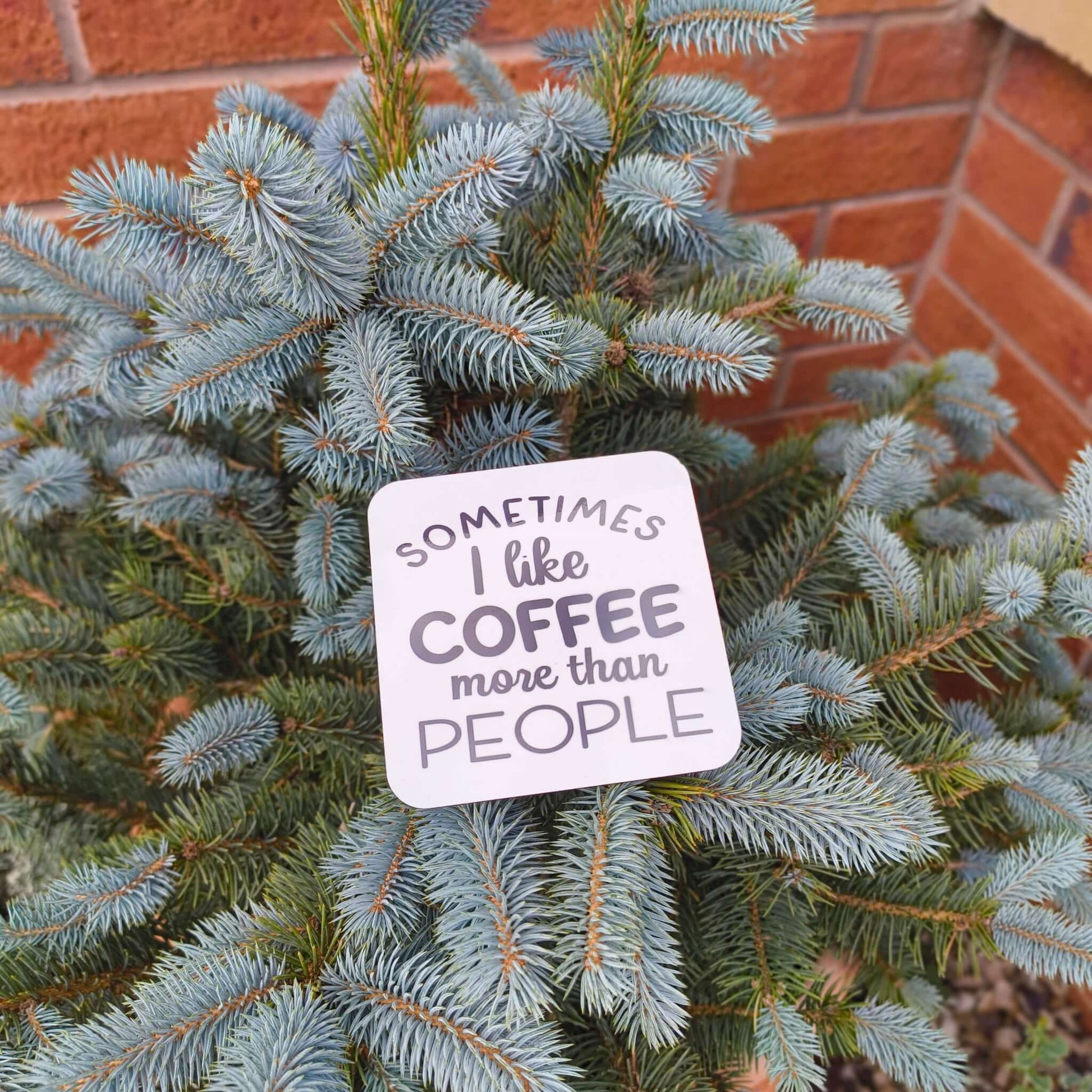Funny coffee coaster gift with the phrase "Sometimes I like coffee more than people" on a tree.