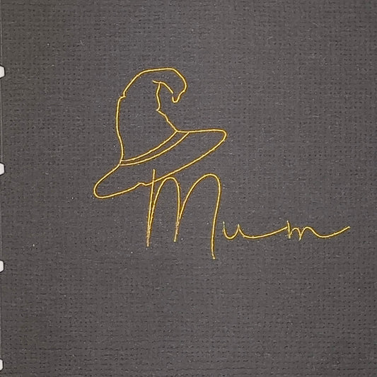 Detailed view of gold foil witch hat illustration and “Mum” text on textured black cracker cardstock