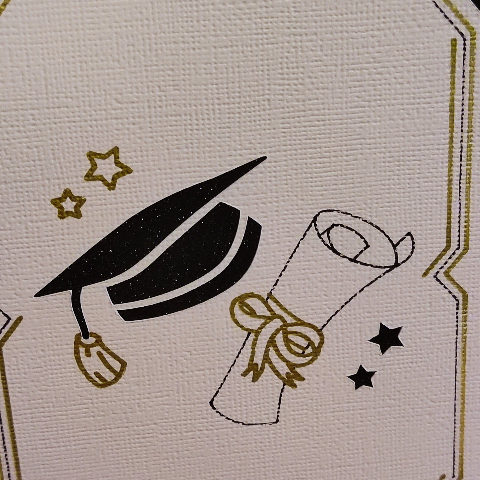 Detailed view of black mortarboard and diploma illustration with gold ribbon and stars, printed on textured ivory card for a handmade finish.