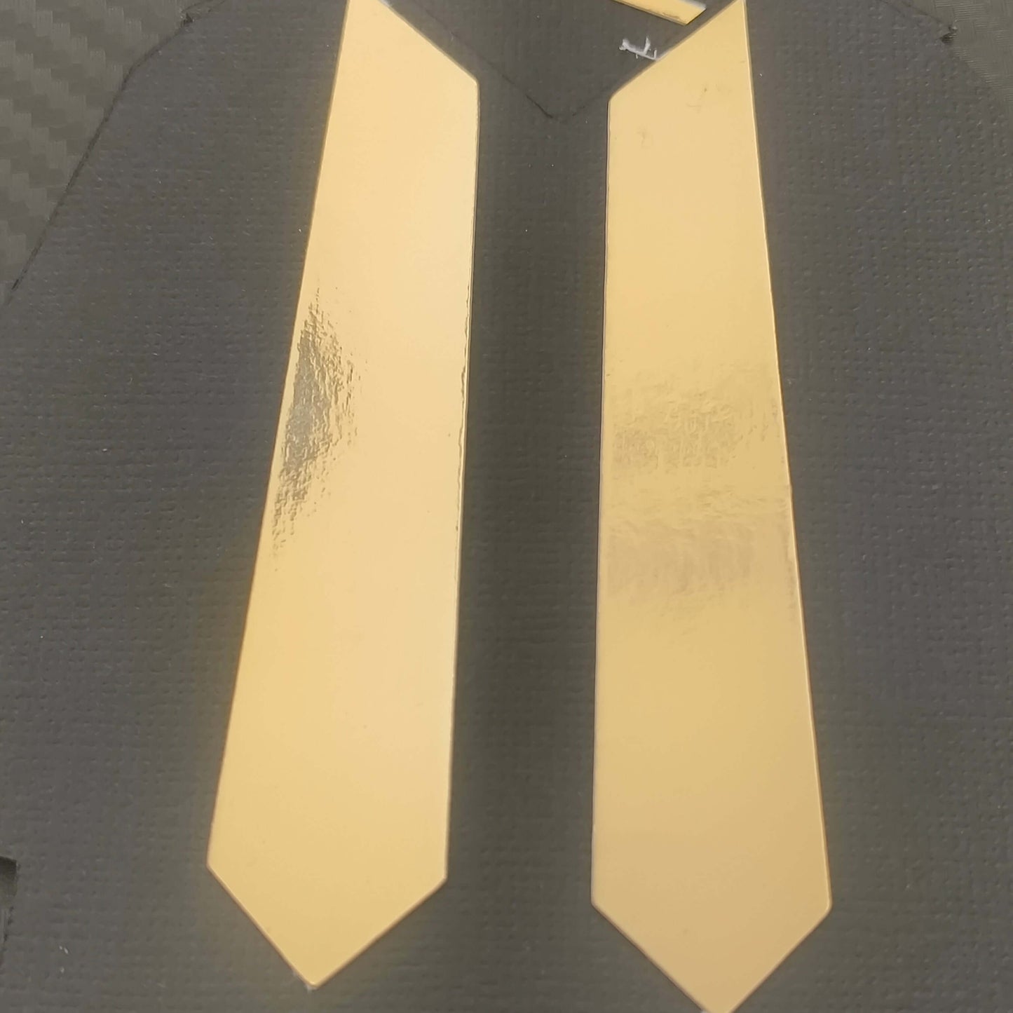 Close-up of graduation gift card holder featuring sophisticated black cardstock with shiny gold foil tie design for university celebrations

