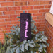 Glittery pink “Groovy & Boozy” wine bag displayed outdoors on a pine tree, sparkly lettering standing out on black fabric.