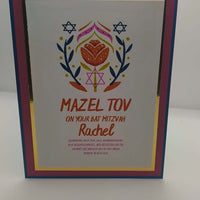 Standing Bat Mitzvah greeting card featuring Mazel Tov message, floral Star of David illustration, and personalised name Rachel, with layered cardstock in blue, pink, and gold.