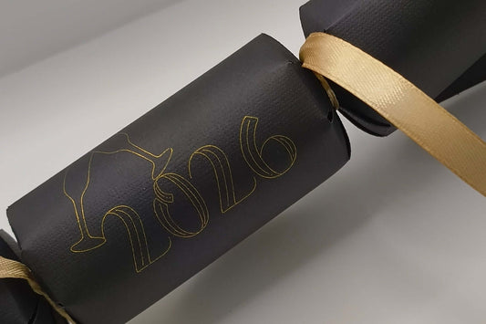 Personalised New Year cracker in black with gold 2026 design and ribbon, perfect for New Year celebrations.