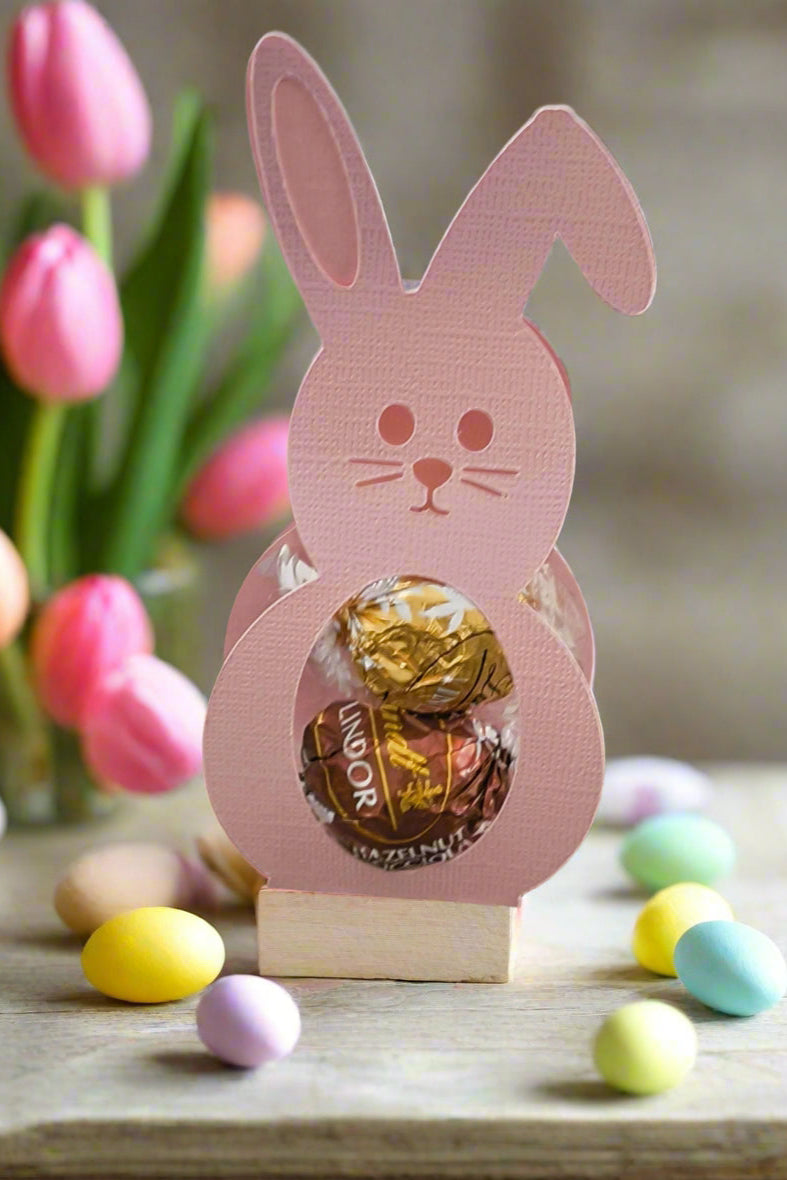 Handmade bunny-shaped Easter chocolate holder with Lindor truffles, decorated with pastel eggs and tulips.