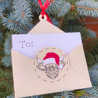 Handmade cream Christmas money holder with Highland cow Santa design hanging on tree branch