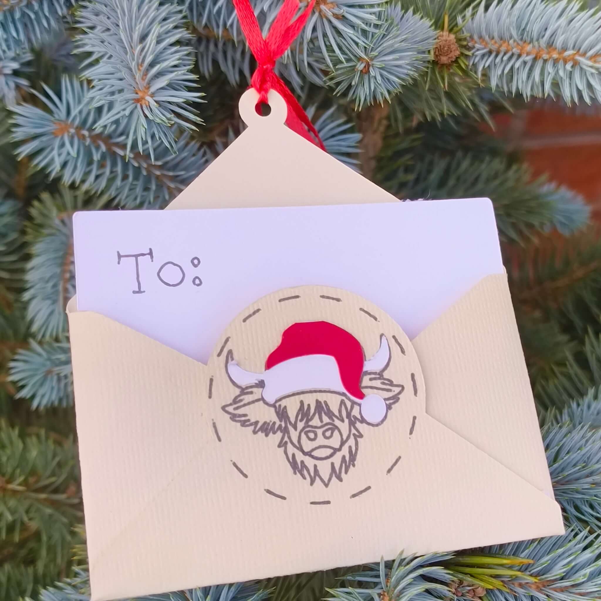 Handmade cream Christmas money holder with Highland cow Santa design hanging on tree branch