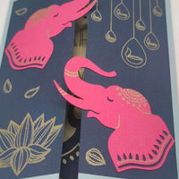 Handmade Diwali Card featuring pink elephants on navy background with gold elements, perfect for celebrations.