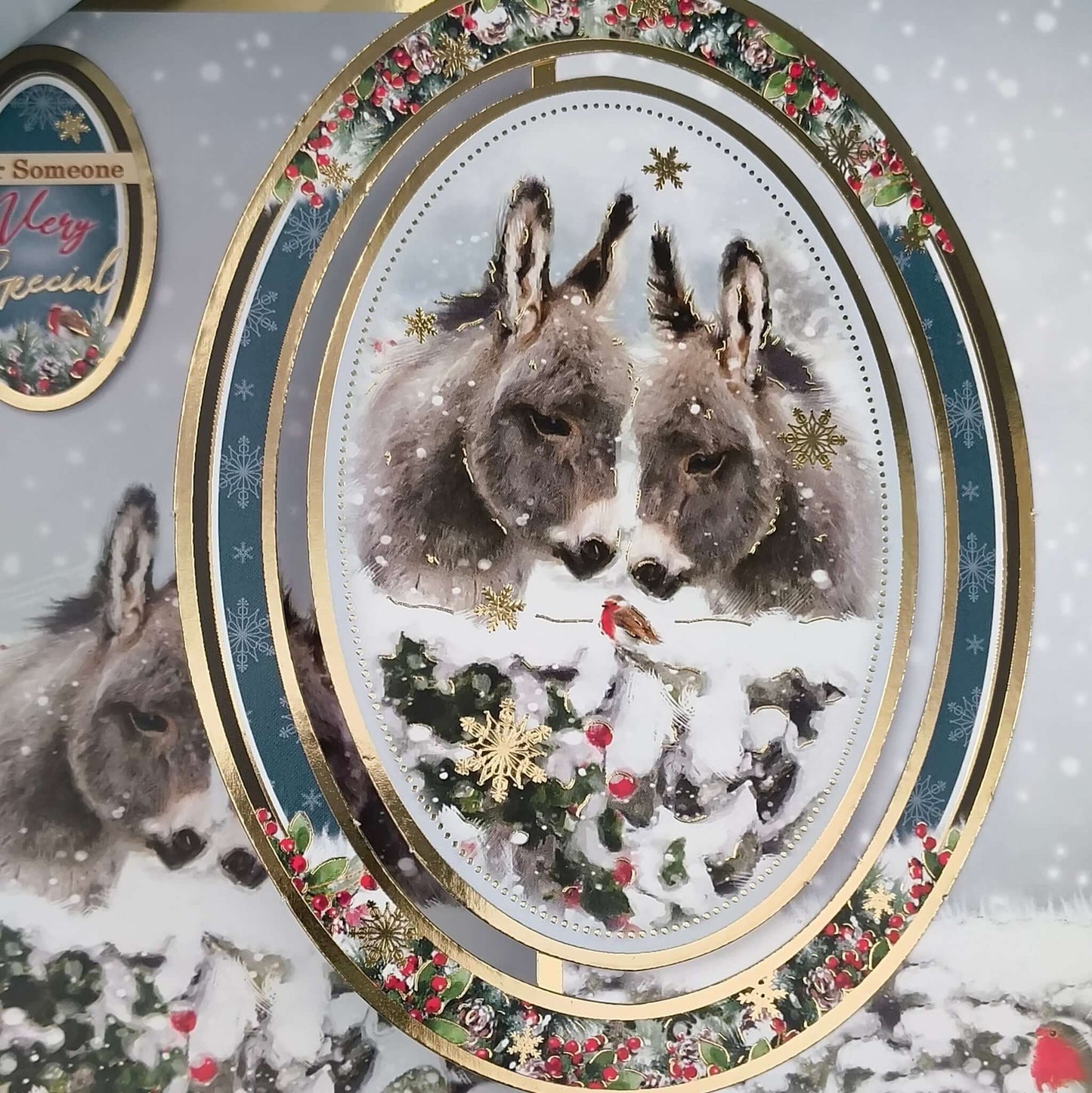 Handmade donkey Christmas card featuring two donkeys in a snowy scene with luxury gold foiling.
