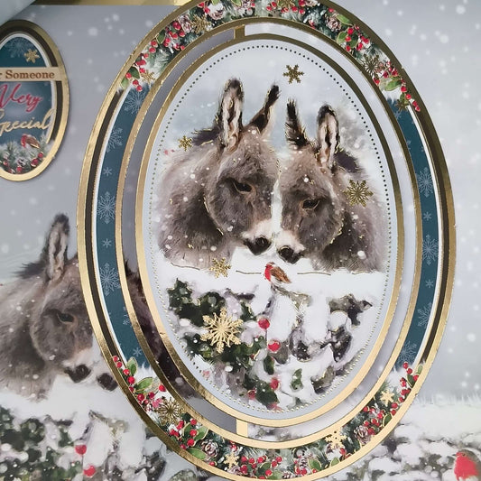 Handmade donkey Christmas card featuring two donkeys in a snowy scene with luxury gold foiling.