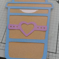 Handmade gift card holder shaped like a coffee cup, decorated with a blue border and a pink heart band.