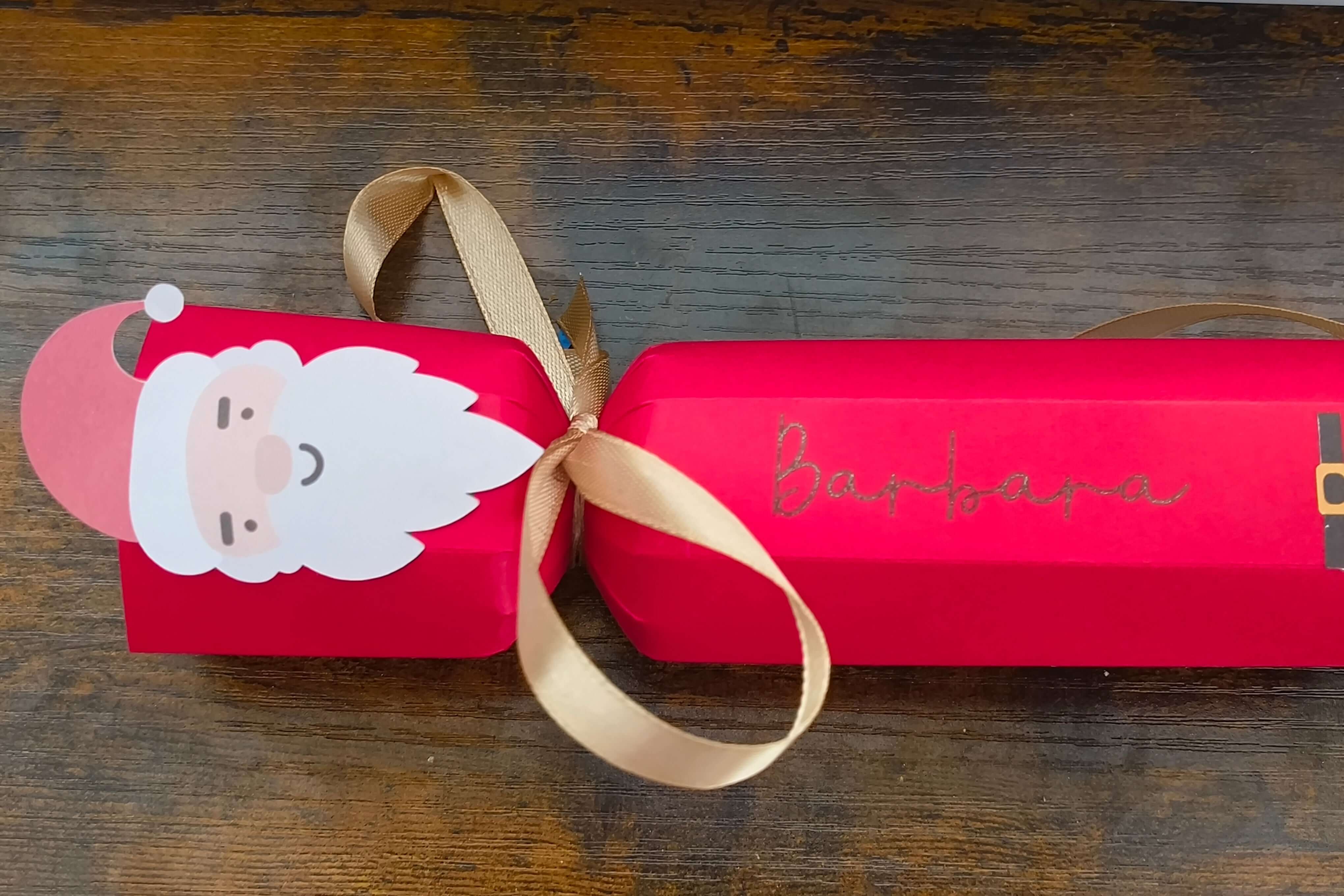 Personalised red Christmas cracker with Santa design and gold ribbon, featuring the name Barbara.