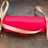 Personalised red Christmas cracker with gold ribbon, perfect for adding a festive touch to your holiday table.