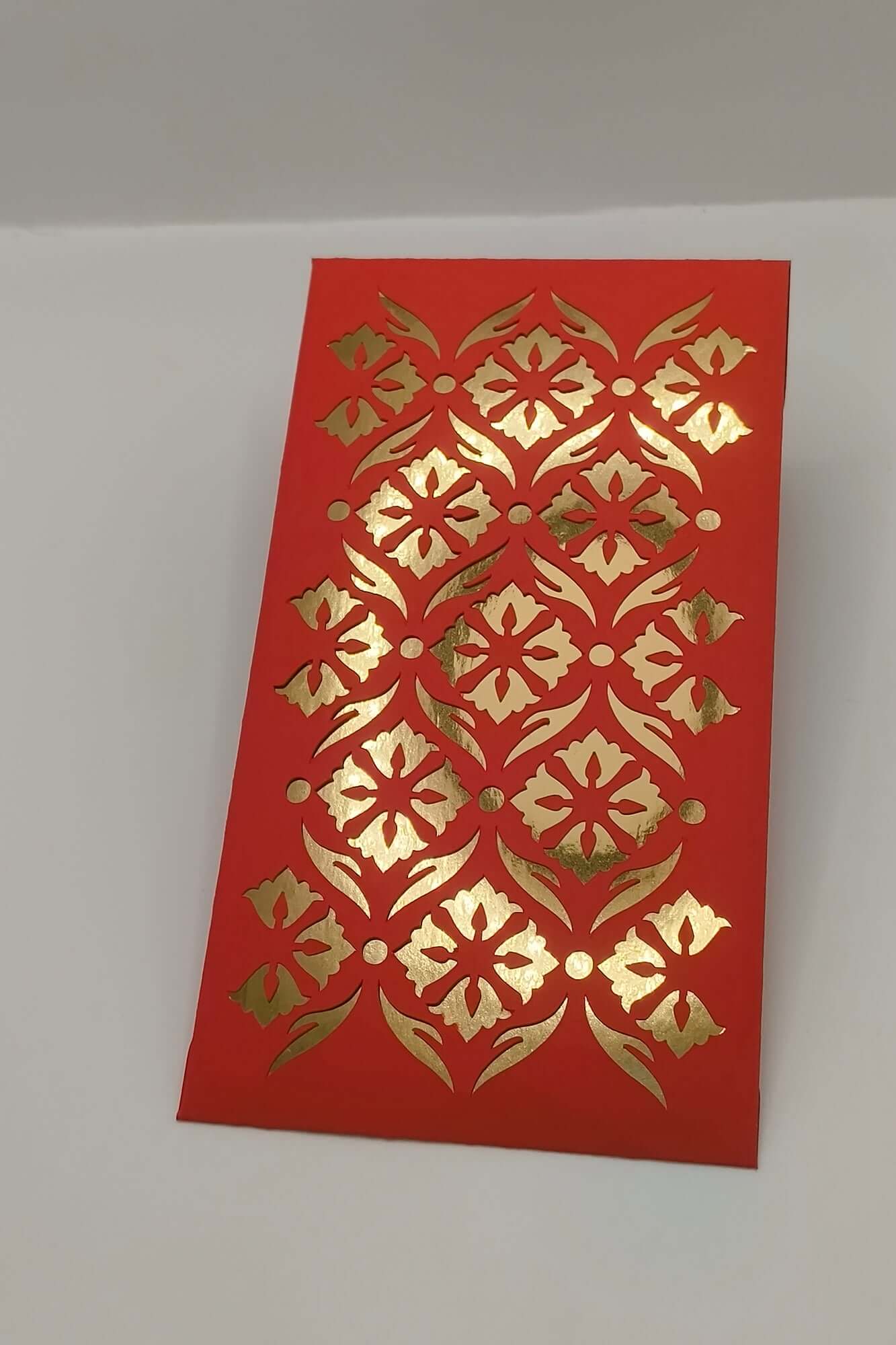 Handmade red and gold money envelope with decorative floral cut-out