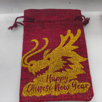 Handmade red hessian bag with gold glitter dragon and “Happy Chinese New Year” message on white background.
