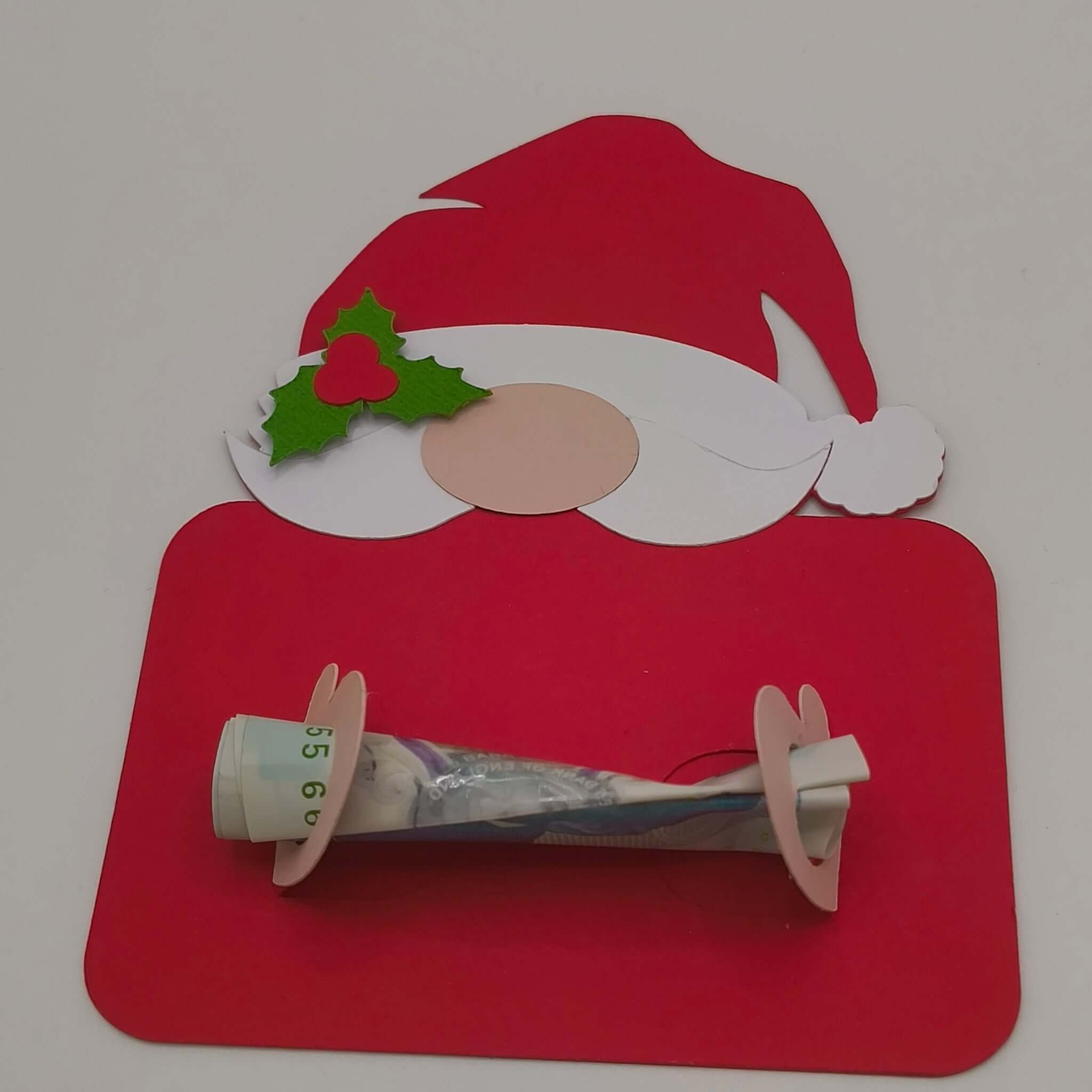 Festive handmade Santa money holder card in red with beard, holly, and nose, holding a rolled banknote securely across the centre.