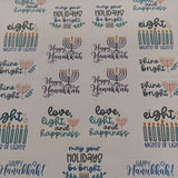 Top-down view of a Hanukkah sticker sheet featuring assorted festive designs including menorahs, candles, and phrases like “Shine Bright,” “Happy Hanukkah,” and “Eight Nights of Lights,” displayed on a white background.