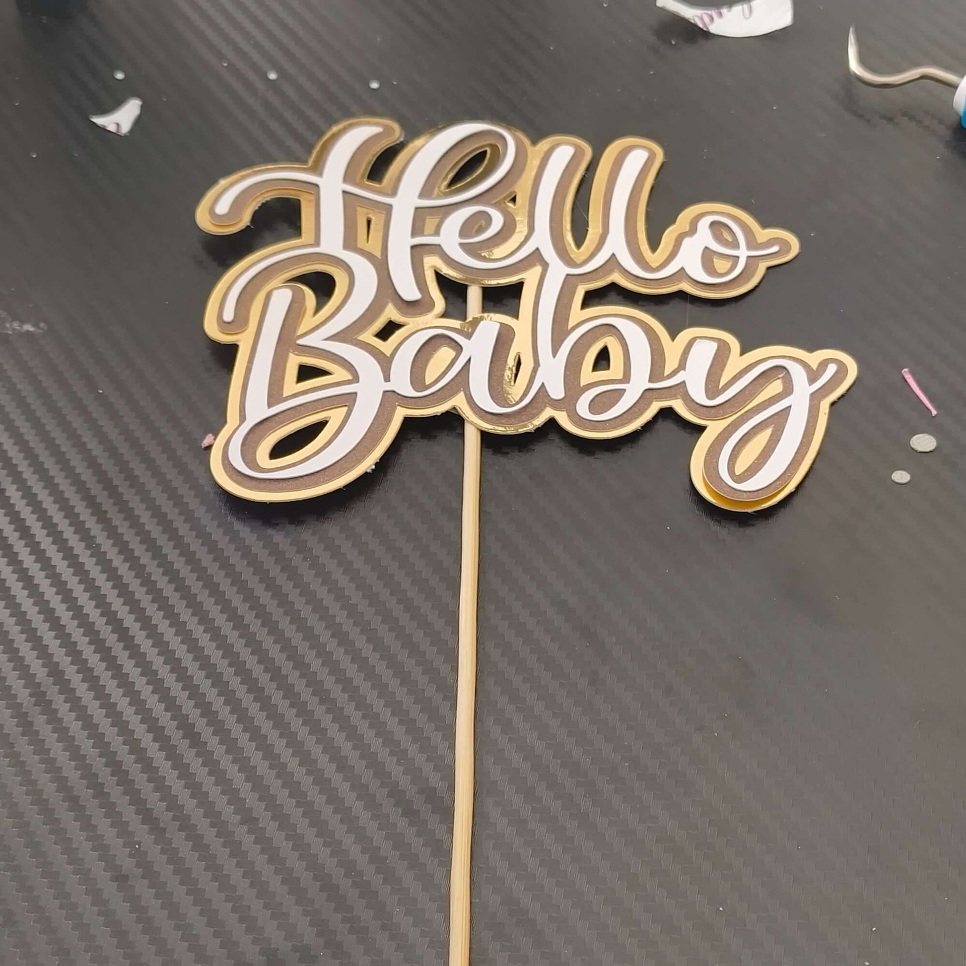 Hello Baby cake topper in gold layered cardstock for baby showers and new baby celebrations.
