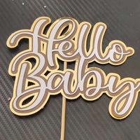 Gold layered cardstock 'Hello Baby' cake topper for baby showers or new baby celebrations.