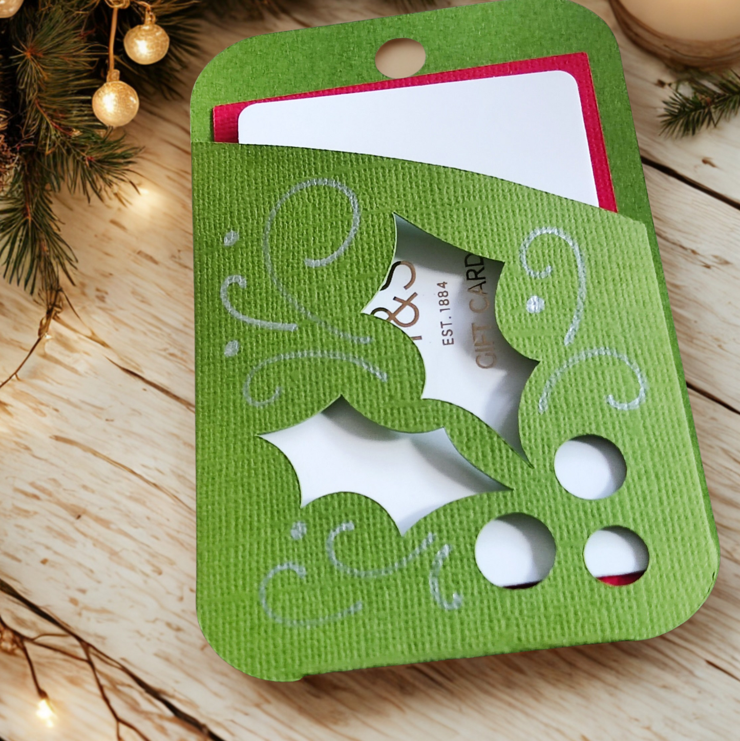 Holly gift card holder in green with cutouts, perfect for presenting Christmas gifts.