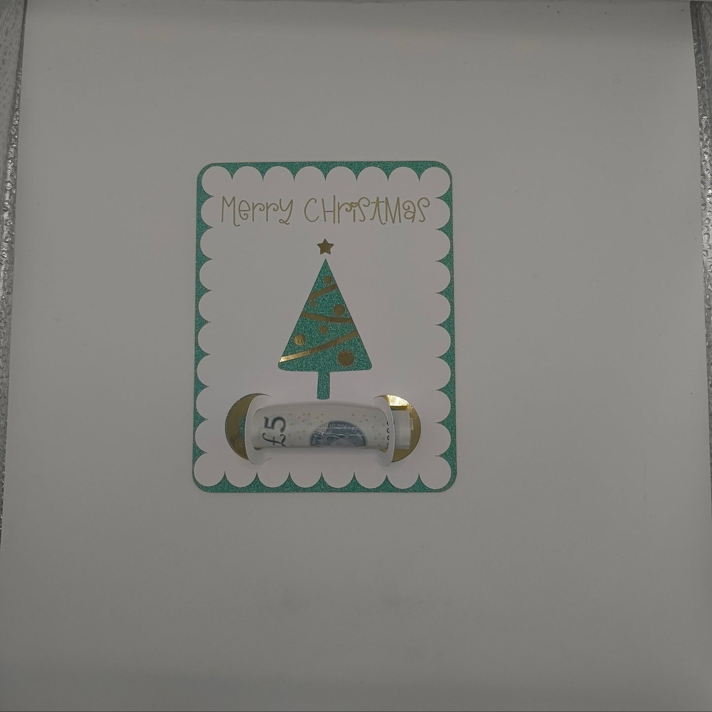 Inside of handmade Christmas card featuring green glitter tree money holder with space for a banknote gift.