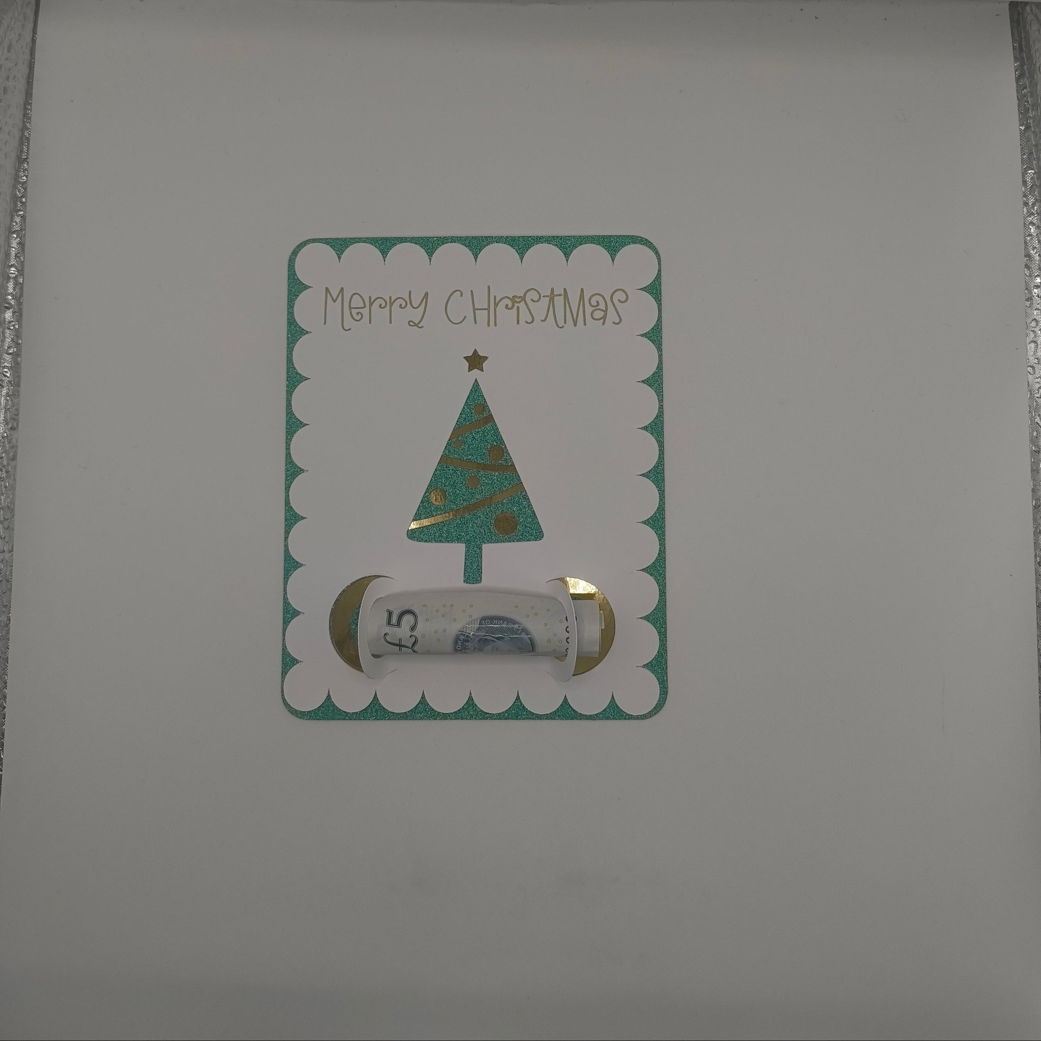 Inside of handmade Christmas card featuring green glitter tree money holder with space for a banknote gift.